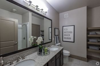 a bathroom with two sinks and a large mirror